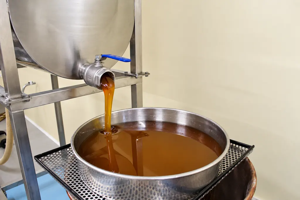 Il miele scende dal rubinetto del maturatore nel filtro, nel laboratorio dell'azienda